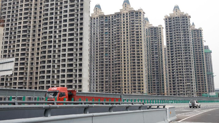 Vehicles drive past unfinished residential buildings from the Evergrande Oasis, a housing complex developed by Evergrande Group, in Luoyang, China September 16, 2021. Picture taken September 16, 2021. REUTERS/Carlos Garcia Rawlins