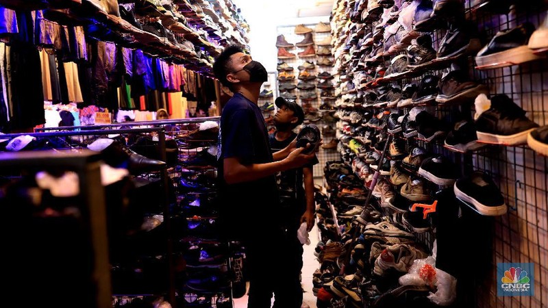 Pengunjung mencari pakaian second di Pasar Senen, Jumat, 15/10. Tren thrifting atau buru pakaian impor yang masih layak pakai berlanjut usai PPKM ketat akibat Corona mereda. Pasar Senen, Jakarta Pusat, merupakan salah satu tujuan yang paling banyak dipilih untuk thrift shop. Penampilan pasar yang semakin nyaman dan modern berkat peremajaan dan dibangun kembali pasca kebakaran pada April 2014 dan Januari 2017 lalu itu, membuat pengunjung betah berbelanja. Pengunjungnya mayoritas kalangan anak muda yang tampil gaya tanpa mengeluarkan banyak biaya, atau mereka yang mencari pakaian unik, branded dan tidak pasaran. Selain baju disini juga menjual sepatu branded second dan aksesoris lain. Harga yang dijual dari Rp20.000 hinggal Rp150 ribu bisa ditawar.  (CNBC Indonesia/ Muhammad Sabki)