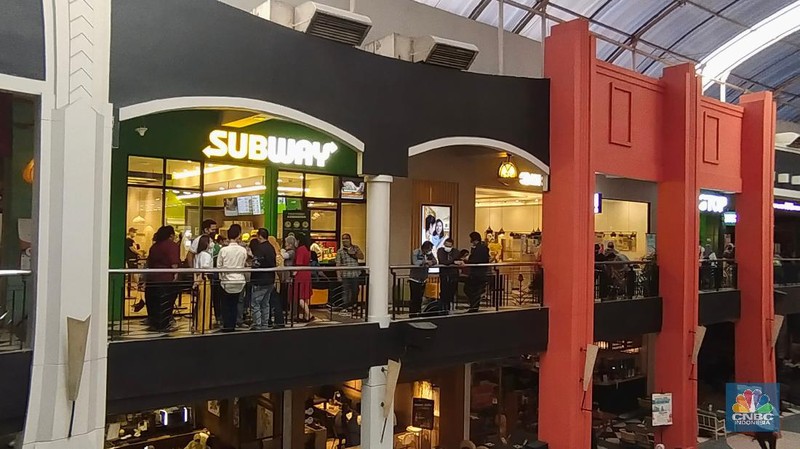 Suasana antrean panjang calon pembeli restoran Subway di Mal Cilandak Town Square, Jakarta, Jumat (15/10/2021). Tingginya minat masyarakat pada restoran sandwich cepat saji asal Amerika Serikat tersebut membuat antrian mengular hingga lebih dari 3 jam. Adapun restoran ini membuka gerai pertamanya setelah 20 tahun hengkang dari Indonesia. Dilokasi para pengunjung dibagi menjadi tiga antrean mulai dari antrean berdiri, duduk di koridor tengah dan antrean terakhir sebelum memasuki gerai. Padatnya pengunjung membuat pihak keamanan kesulitan dalam mengatur jaga jarak. 
  (CNBC Indonesia/ Tri Susilo)