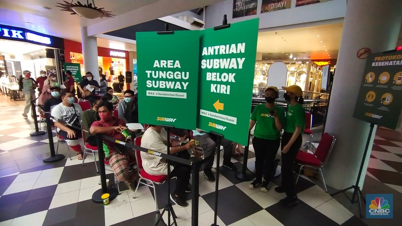 Suasana hari pertama pembukaan Subway Indonesia di Mal Cilandak Town Square, Suasana antrean panjang calon pembeli restoran Subway di Mal Cilandak Town Square, Jakarta, Jumat (15/10/2021). Tingginya minat masyarakat pada restoran sandwich cepat saji asal Amerika Serikat tersebut membuat antrian mengular hingga lebih dari 3 jam. Adapun restoran ini membuka gerai pertamanya setelah 20 tahun hengkang dari Indonesia. Dilokasi para pengunjung dibagi menjadi tiga antrean mulai dari antrean berdiri, duduk di koridor tengah dan antrean terakhir sebelum memasuki gerai. Padatnya pengunjung membuat pihak keamanan kesulitan dalam mengatur jaga jarak.
(CNBC Indonesia/ Tri Susilo)