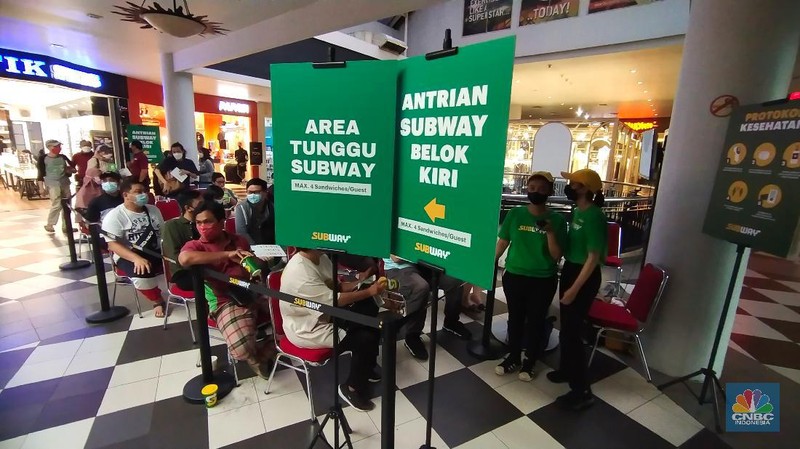 Suasana antrean panjang calon pembeli restoran Subway di Mal Cilandak Town Square, Jakarta, Jumat (15/10/2021). Tingginya minat masyarakat pada restoran sandwich cepat saji asal Amerika Serikat tersebut membuat antrian mengular hingga lebih dari 3 jam. Adapun restoran ini membuka gerai pertamanya setelah 20 tahun hengkang dari Indonesia. Dilokasi para pengunjung dibagi menjadi tiga antrean mulai dari antrean berdiri, duduk di koridor tengah dan antrean terakhir sebelum memasuki gerai. Padatnya pengunjung membuat pihak keamanan kesulitan dalam mengatur jaga jarak. 
  (CNBC Indonesia/ Tri Susilo)