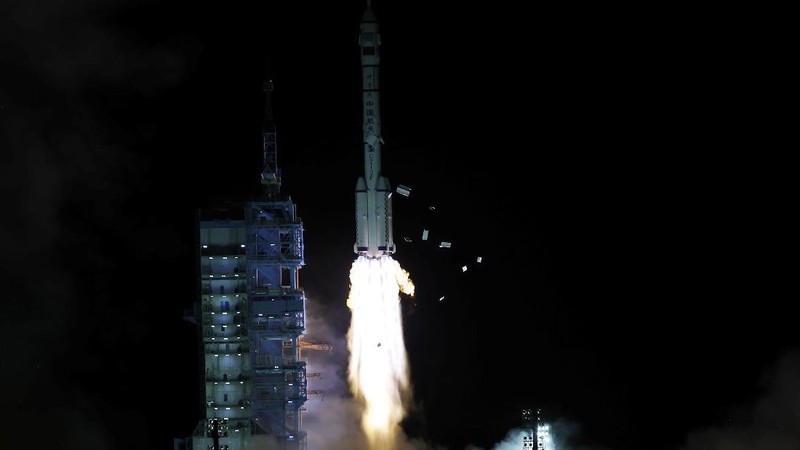 In this photo released by Xinhua News Agency, screen image captured at Beijing Aerospace Control Center in Beijing, China, Saturday, Oct. 16, 2021 shows three Chinese astronauts, from left, Ye Guangfu, Zhai Zhigang and Wang Yaping waving after entering the space station core module Tianhe. China's Shenzhou-13 spacecraft carrying three Chinese astronauts on Saturday docked at its space station, kicking off a record-setting six-month stay as the country moves toward completing the new orbiting outpost. Chinese characters,  left, read 