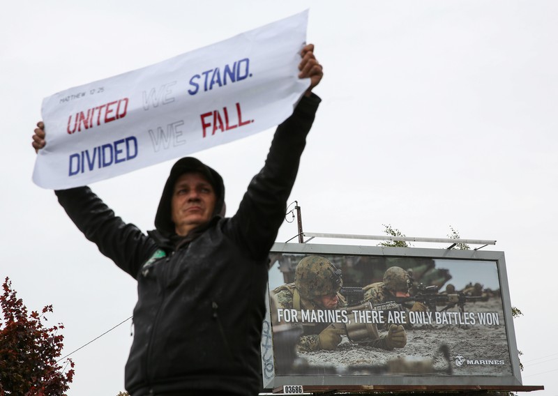 HEALTH-CORONAVIRUS/USA-VACCINES Boeing employees and others line the street with signs and American flags as they protest the company's coronavirus disease (COVID-19) vaccine mandate, outside the Boeing facility in Everett, Washington, October 15, 2021. REUTERS/Lindsey Wasson