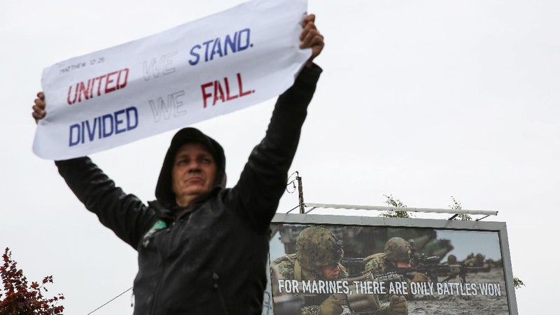 Boeing employees and others line the street with signs and American flags as they protest the company's coronavirus disease (COVID-19) vaccine mandate, outside the Boeing facility in Everett, Washington, October 15, 2021.  REUTERS/Lindsey Wasson