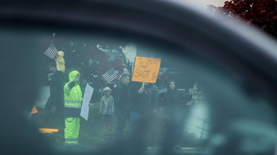 Boeing employees and others line the street with signs and American flags as they protest the company's coronavirus disease (COVID-19) vaccine mandate, outside the Boeing facility in Everett, Washington, October 15, 2021.  REUTERS/Lindsey Wasson