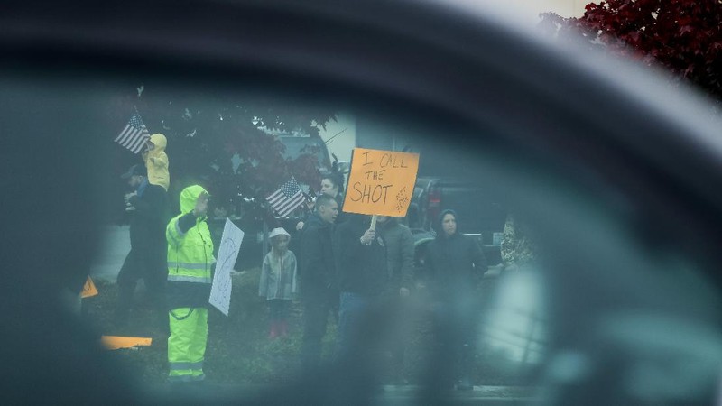 Boeing employees and others line the street with signs and American flags as they protest the company's coronavirus disease (COVID-19) vaccine mandate, outside the Boeing facility in Everett, Washington, October 15, 2021.  REUTERS/Lindsey Wasson
