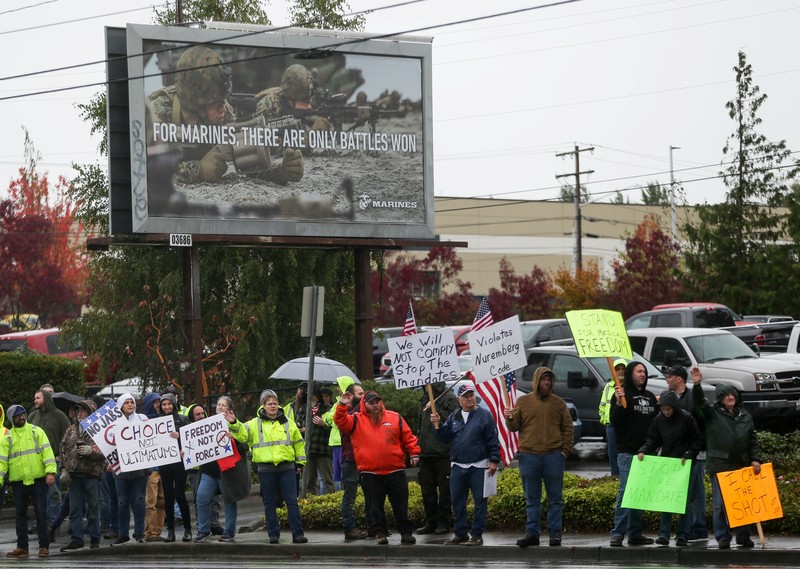 HEALTH-CORONAVIRUS/USA-VACCINES Boeing employees and others line the street with signs and American flags as they protest the company's coronavirus disease (COVID-19) vaccine mandate, outside the Boeing facility in Everett, Washington, October 15, 2021. REUTERS/Lindsey Wasson
