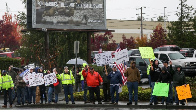Boeing employees and others line the street with signs and American flags as they protest the company's coronavirus disease (COVID-19) vaccine mandate, outside the Boeing facility in Everett, Washington, October 15, 2021.  REUTERS/Lindsey Wasson