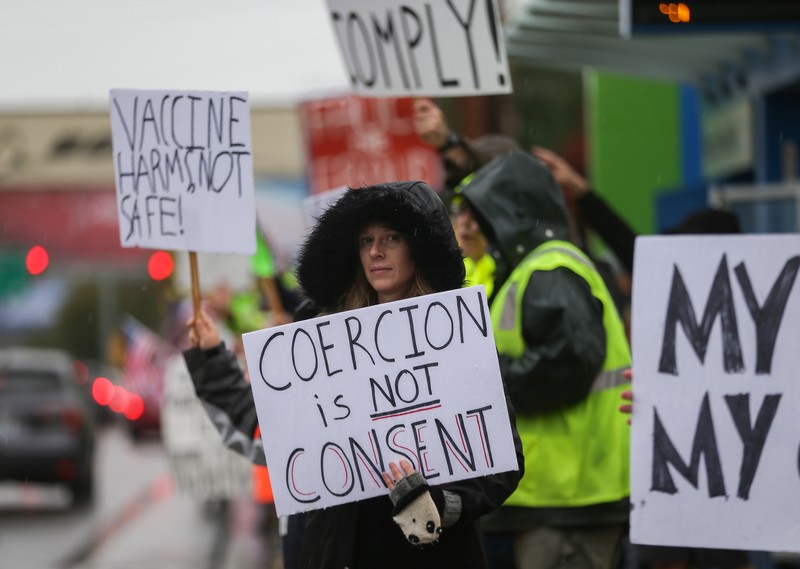 Boeing employees and others line the street with signs and American flags as they protest the company's coronavirus disease (COVID-19) vaccine mandate, outside the Boeing facility in Everett, Washington, October 15, 2021.  REUTERS/Lindsey Wasson