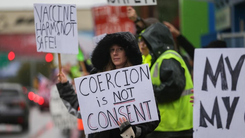 Boeing employees and others line the street with signs and American flags as they protest the company's coronavirus disease (COVID-19) vaccine mandate, outside the Boeing facility in Everett, Washington, October 15, 2021.  REUTERS/Lindsey Wasson