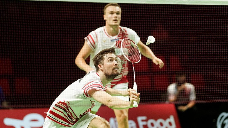 Indonesia's Anthony Sinisuka Ginting returns the shuttlecock to Denmark's Viktor Axelsen during a mens single match in the Thomas Cup mens team Badminton semifinal match between Denmark and Indonesia, in Aarhus, Denmark, Saturday Oct. 16, 2021. (Claus Fisker/Ritzau Scanpix via AP)