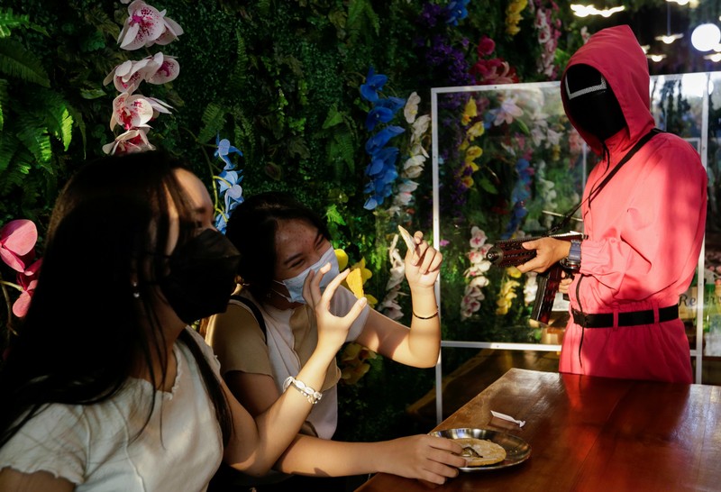 INDONESIA-DAILYLIFE/SQUIDGAME Customers play Squid Game's honeycomb toffee game at Strawberry Cafe in Jakarta, Indonesia, October 15, 2021. REUTERS/Ajeng Dinar Ulfiana TPX IMAGES OF THE DAY