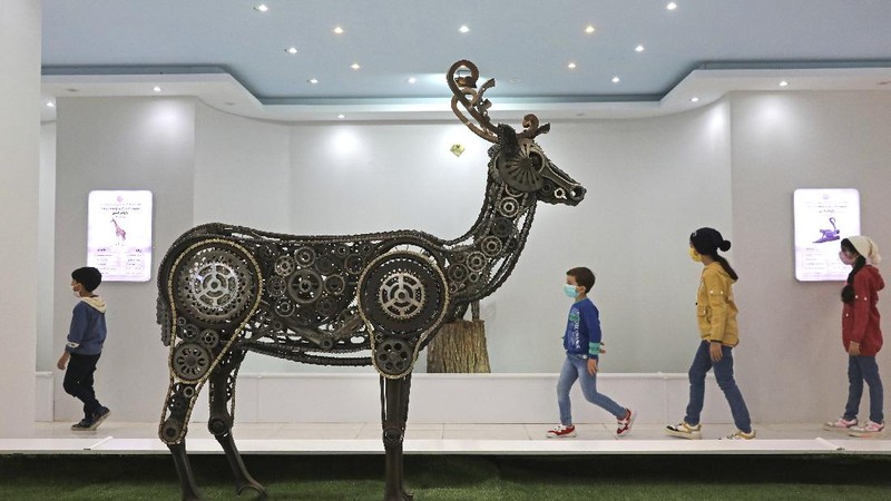 Children visit indoor area of Shahreza Metal Zoo in the central city of Shahreza some 265 miles (425 kilometer) south of the capital Tehran, Iran, Wednesday, Oct. 13, 2021. The zoo hosts 30 life-sized animal sculptures of two Iranian artist brothers. Ehsan and Soheil Saanei have made the sculptures with thousands of salvaged bearings, gears, cogwheels, chains, nuts, and bolts meshed with each other to create elaborate animals that capture the form of its real-life creature in metal. A message to both show their opposition to traditional zoos and at the same time help the city with recycling of the discarded metal parts through their project. (AP Photo/Vahid Salemi)