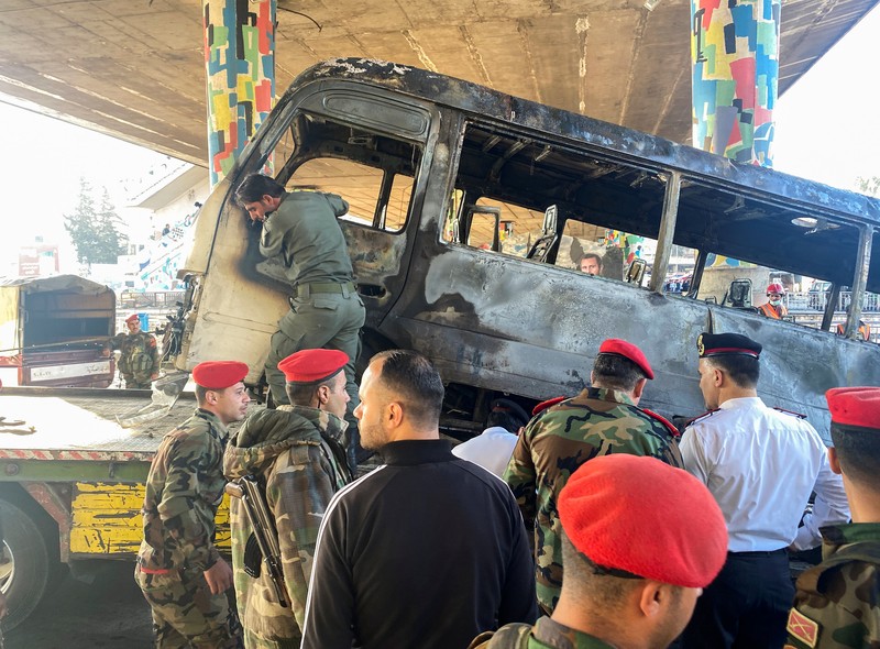 Ledakan bom bus militer di Suriah A civil defense member hoses down a bus at the site of a roadside bomb attack in central Damascus, Syria, in this handout released by SANA October 20, 2021. SANA/Handout via REUTERS ATTENTION EDITORS - THIS IMAGE WAS PROVIDED BY A THIRD PARTY. REUTERS IS UNABLE TO INDEPENDENTLY VERIFY THIS IMAGE.
