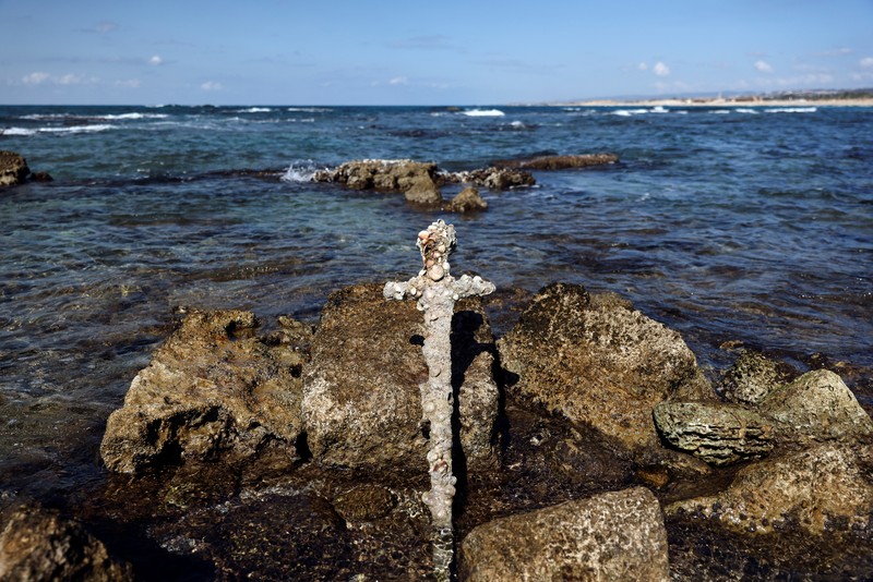 Penemuan pedang kuno berusia ratusan tahun di lepas pantai Haifa, Israel A sword believed to have belonged to a Crusader who sailed to the Holy Land almost a millennium ago lays on the beach near to where it was recovered from the Mediterranean seabed by an amateur diver, the Israel Antiquities Authority said, Caesarea, Israel October 18, 2021. REUTERS/Ronen Zvulun