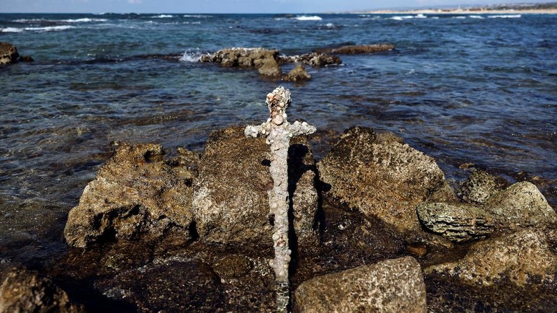 A sword believed to have belonged to a Crusader who sailed to the Holy Land almost a millennium ago lays on the beach near to where it was recovered from the Mediterranean seabed by an amateur diver, the Israel Antiquities Authority said, Caesarea, Israel October 18, 2021. REUTERS/Ronen Zvulun