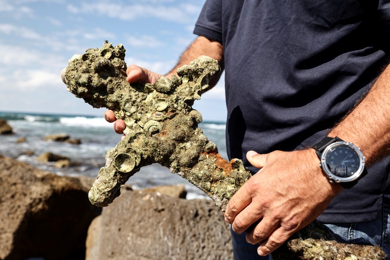 Penemuan pedang kuno berusia ratusan tahun di lepas pantai Haifa, Israel A sword believed to have belonged to a Crusader who sailed to the Holy Land almost a millennium ago lays on the beach near to where it was recovered from the Mediterranean seabed by an amateur diver, the Israel Antiquities Authority said, Caesarea, Israel October 18, 2021. REUTERS/Ronen Zvulun
