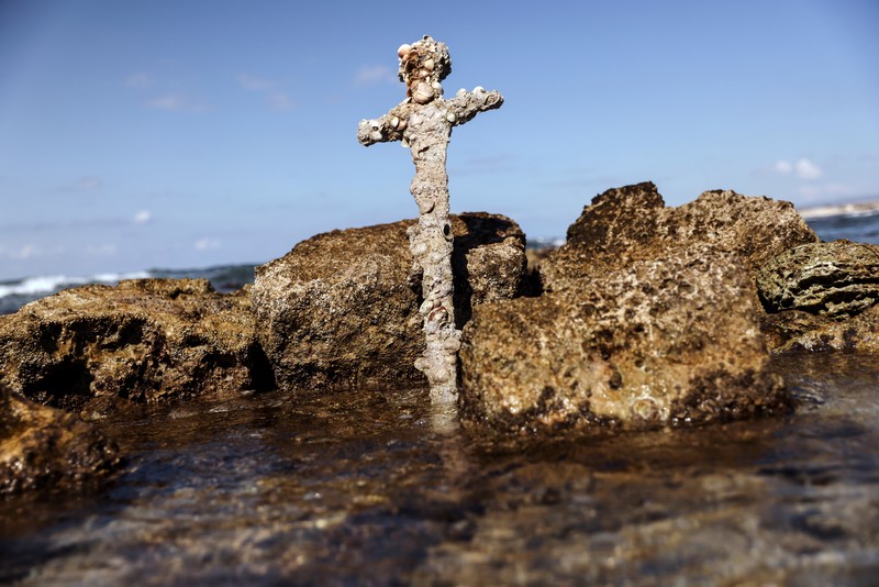 Penemuan pedang kuno berusia ratusan tahun di lepas pantai Haifa, Israel A sword believed to have belonged to a Crusader who sailed to the Holy Land almost a millennium ago lays on the beach near to where it was recovered from the Mediterranean seabed by an amateur diver, the Israel Antiquities Authority said, Caesarea, Israel October 18, 2021. REUTERS/Ronen Zvulun