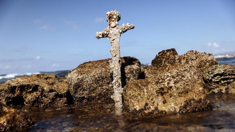 A sword believed to have belonged to a Crusader who sailed to the Holy Land almost a millennium ago lays on the beach near to where it was recovered from the Mediterranean seabed by an amateur diver, the Israel Antiquities Authority said, Caesarea, Israel October 18, 2021. REUTERS/Ronen Zvulun