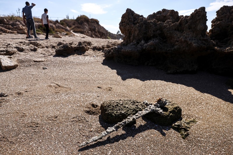 Penemuan pedang kuno berusia ratusan tahun di lepas pantai Haifa, Israel A sword believed to have belonged to a Crusader who sailed to the Holy Land almost a millennium ago lays on the beach near to where it was recovered from the Mediterranean seabed by an amateur diver, the Israel Antiquities Authority said, Caesarea, Israel October 18, 2021. REUTERS/Ronen Zvulun