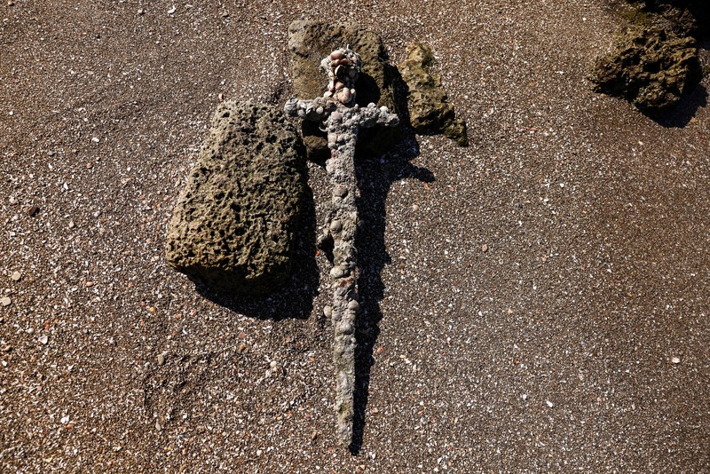 Penemuan pedang kuno berusia ratusan tahun di lepas pantai Haifa, Israel A sword believed to have belonged to a Crusader who sailed to the Holy Land almost a millennium ago lays on the beach near to where it was recovered from the Mediterranean seabed by an amateur diver, the Israel Antiquities Authority said, Caesarea, Israel October 18, 2021. REUTERS/Ronen Zvulun