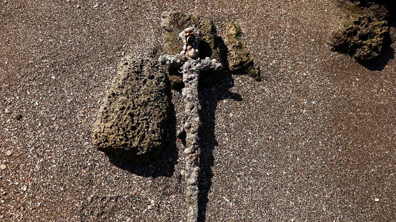 A sword believed to have belonged to a Crusader who sailed to the Holy Land almost a millennium ago lays on the beach near to where it was recovered from the Mediterranean seabed by an amateur diver, the Israel Antiquities Authority said, Caesarea, Israel October 18, 2021. REUTERS/Ronen Zvulun