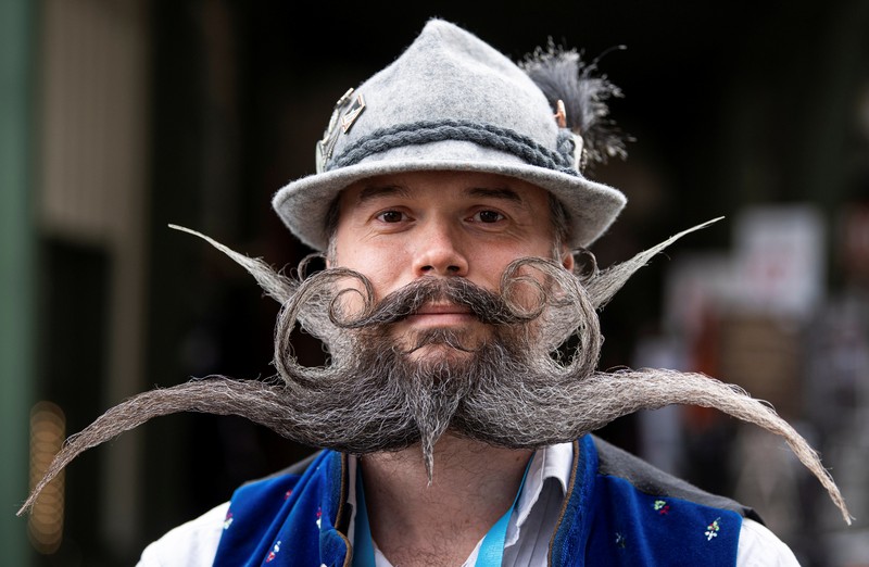 Peserta kejuaraan kumis dan jenggot Jerman 2021 Participant Norbert Dopf from Austria arrives for the German Moustache and Beard Championships 2021 at Pullman City Western Theme Park in Eging am See, Germany, October 23, 2021. REUTERS/Lukas Barth TPX IMAGES OF THE DAY