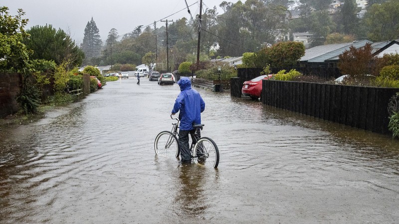 Vehicles make their way through a flooded area of High Street near Interstate 880 as rain falls in Oakland, Calif., on Sunday, Oct. 24, 2021. (Jane Tyska/Bay Area News Group via AP)