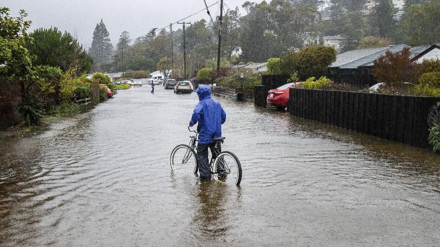 Vehicles make their way through a flooded area of High Street near Interstate 880 as rain falls in Oakland, Calif., on Sunday, Oct. 24, 2021. (Jane Tyska/Bay Area News Group via AP)