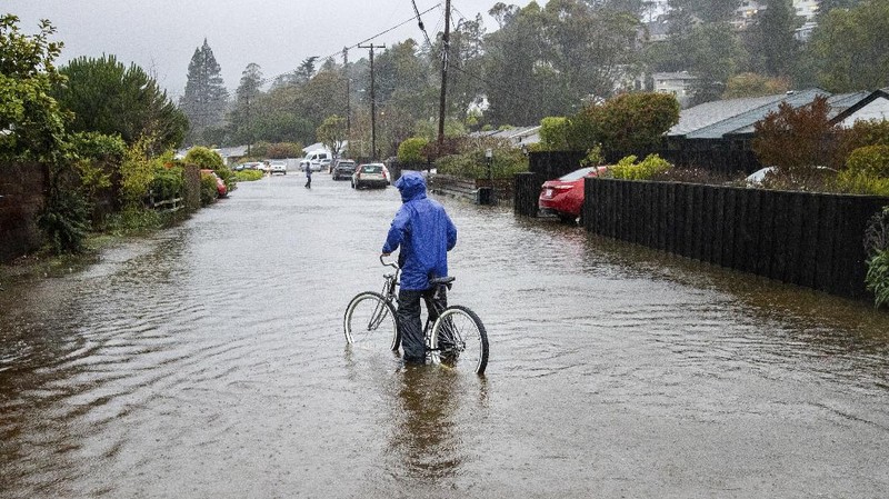 Vehicles make their way through a flooded area of High Street near Interstate 880 as rain falls in Oakland, Calif., on Sunday, Oct. 24, 2021. (Jane Tyska/Bay Area News Group via AP)
