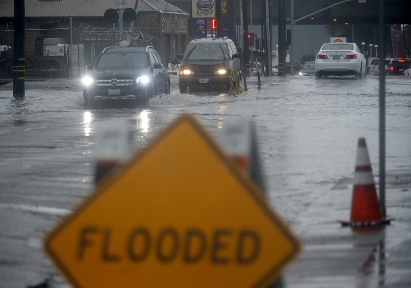 Vehicles make their way through a flooded area of High Street near Interstate 880 as rain falls in Oakland, Calif., on Sunday, Oct. 24, 2021. (Jane Tyska/Bay Area News Group via AP)