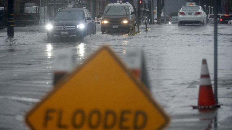 Vehicles make their way through a flooded area of High Street near Interstate 880 as rain falls in Oakland, Calif., on Sunday, Oct. 24, 2021. (Jane Tyska/Bay Area News Group via AP)