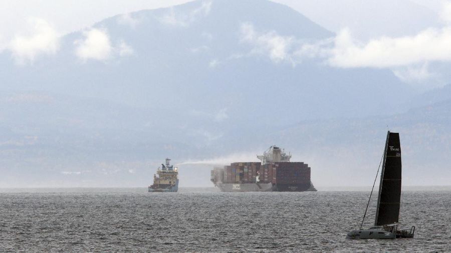 Ships work to control a fire onboard the MV Zim Kingston about 8 kilometers (5 miles) from the shore in Victoria, British Columbia, Canaeda, on Sunday, Oct. 24, 2021. The container ship caught fire on Saturday and 16 crew members were evacuated and brought to Ogden Point Pier. (Chad Hipolito/The Canadian Press via AP)
