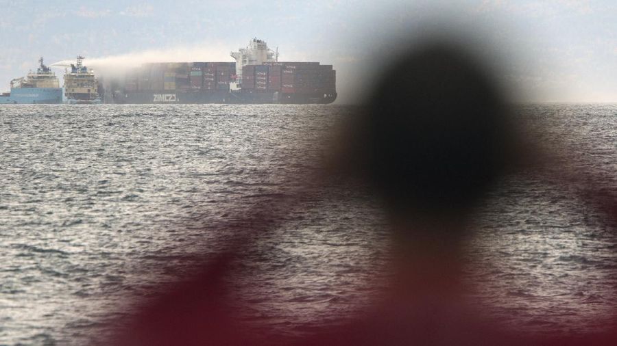 Ships work to control a fire onboard the MV Zim Kingston about 8 kilometers (5 miles) from the shore in Victoria, British Columbia, Canaeda, on Sunday, Oct. 24, 2021. The container ship caught fire on Saturday and 16 crew members were evacuated and brought to Ogden Point Pier. (Chad Hipolito/The Canadian Press via AP)