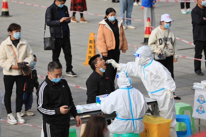 This photo released by Xinhua News Agency shows an aerial view of residents lining up to receive a swab for the coronavirus test during a mass testing in Lanzhou, capital city of northwest China's Gansu Province, Sunday, Oct. 24, 2021. China's Gansu has closed all tourist sites following the reporting of new COVID-19 cases in the northwestern province. Gansu lies along the ancient Silk Road and is famed for the Dunhuang grottoes filled with Buddhist images and other ancient religious sites. (Fan Peishen/Xinhua via AP)