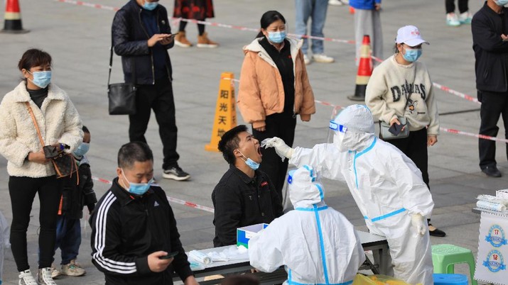 HEALTH-CORONAVIRUS/CHINA A medical worker in protective suit collects a swab from a man during a mass nucleic acid testing in Huichuan district following new cases of the coronavirus disease (COVID-19) in Zunyi, Guizhou province, China October 23, 2021. Picture taken October 23, 2021. cnsphoto via REUTERS ATTENTION EDITORS - THIS IMAGE WAS PROVIDED BY A THIRD PARTY. CHINA OUT.