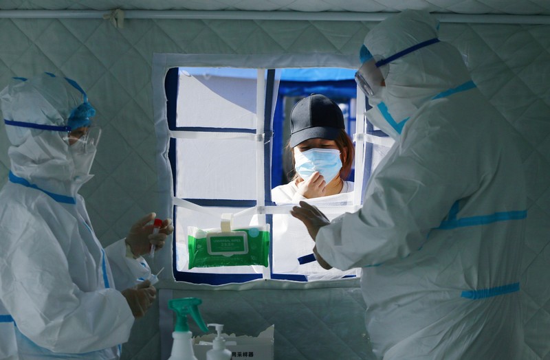 A medical worker in protective suit checks the information of a resident during a mass nucleic acid testing following a new case of the coronavirus disease (COVID-19) in Haidong's Pingan district, Qinghai province, China October 23, 2021. Picture taken October 23, 2021. cnsphoto via REUTERS   ATTENTION EDITORS - THIS IMAGE WAS PROVIDED BY A THIRD PARTY. CHINA OUT.