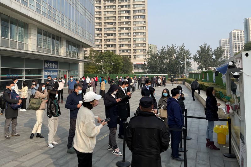 This photo released by Xinhua News Agency shows an aerial view of residents lining up to receive a swab for the coronavirus test during a mass testing in Lanzhou, capital city of northwest China's Gansu Province, Sunday, Oct. 24, 2021. China's Gansu has closed all tourist sites following the reporting of new COVID-19 cases in the northwestern province. Gansu lies along the ancient Silk Road and is famed for the Dunhuang grottoes filled with Buddhist images and other ancient religious sites. (Fan Peishen/Xinhua via AP)