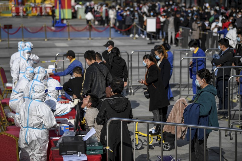 This photo released by Xinhua News Agency shows an aerial view of residents lining up to receive a swab for the coronavirus test during a mass testing in Lanzhou, capital city of northwest China's Gansu Province, Sunday, Oct. 24, 2021. China's Gansu has closed all tourist sites following the reporting of new COVID-19 cases in the northwestern province. Gansu lies along the ancient Silk Road and is famed for the Dunhuang grottoes filled with Buddhist images and other ancient religious sites. (Fan Peishen/Xinhua via AP)
