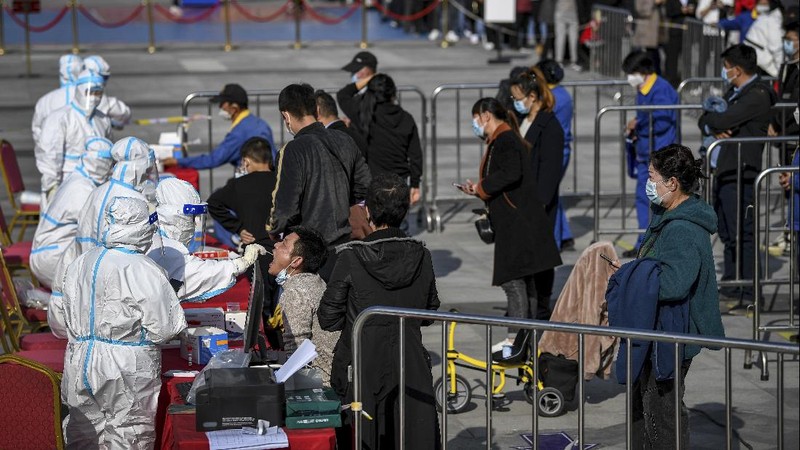 This photo released by Xinhua News Agency shows an aerial view of residents lining up to receive a swab for the coronavirus test during a mass testing in Lanzhou, capital city of northwest China's Gansu Province, Sunday, Oct. 24, 2021. China's Gansu has closed all tourist sites following the reporting of new COVID-19 cases in the northwestern province. Gansu lies along the ancient Silk Road and is famed for the Dunhuang grottoes filled with Buddhist images and other ancient religious sites. (Fan Peishen/Xinhua via AP)