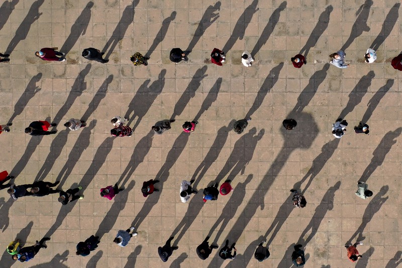 This photo released by Xinhua News Agency shows an aerial view of residents lining up to receive a swab for the coronavirus test during a mass testing in Lanzhou, capital city of northwest China's Gansu Province, Sunday, Oct. 24, 2021. China's Gansu has closed all tourist sites following the reporting of new COVID-19 cases in the northwestern province. Gansu lies along the ancient Silk Road and is famed for the Dunhuang grottoes filled with Buddhist images and other ancient religious sites. (Fan Peishen/Xinhua via AP)