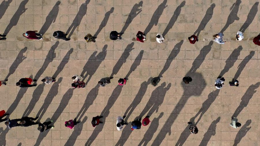 This photo released by Xinhua News Agency shows an aerial view of residents lining up to receive a swab for the coronavirus test during a mass testing in Lanzhou, capital city of northwest China's Gansu Province, Sunday, Oct. 24, 2021. China's Gansu has closed all tourist sites following the reporting of new COVID-19 cases in the northwestern province. Gansu lies along the ancient Silk Road and is famed for the Dunhuang grottoes filled with Buddhist images and other ancient religious sites. (Fan Peishen/Xinhua via AP)