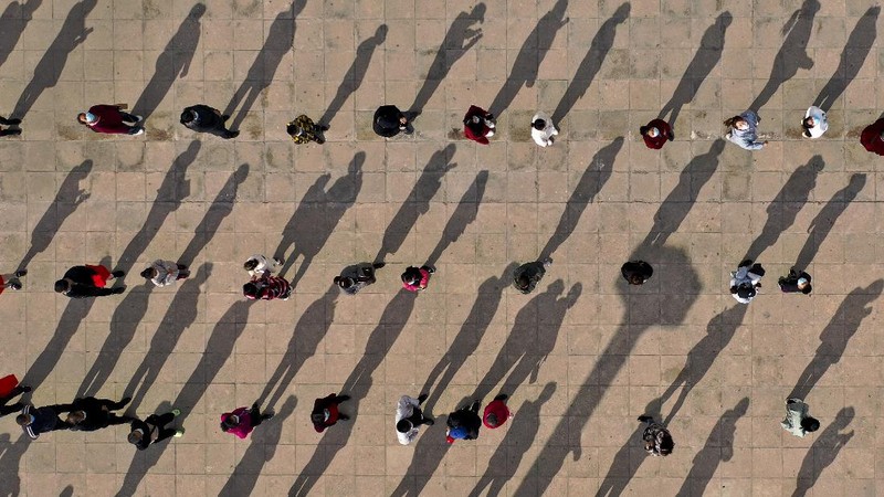 This photo released by Xinhua News Agency shows an aerial view of residents lining up to receive a swab for the coronavirus test during a mass testing in Lanzhou, capital city of northwest China's Gansu Province, Sunday, Oct. 24, 2021. China's Gansu has closed all tourist sites following the reporting of new COVID-19 cases in the northwestern province. Gansu lies along the ancient Silk Road and is famed for the Dunhuang grottoes filled with Buddhist images and other ancient religious sites. (Fan Peishen/Xinhua via AP)