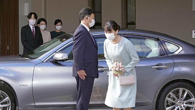 Japan's Princess Mako, right, hugs her sister Princess Kako, watched by her parents Crown Prince Akishino and Crown Princess Kiko, before leaving her home in Akasaka Estate in Tokyo Tuesday, Oct. 26, 2021. Mako and her commoner boyfriend Kei Komuro tied the knot Tuesday without wedding celebration in a marriage that has split the public opinion over her would-be mother-in-law’s financial controversy.  (Koki Sengoku/Kyodo News via AP)