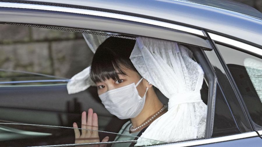 Japan's Princess Mako waves from a car as she leaves her home in Akasaka Estate in Tokyo Tuesday, Oct. 26, 2021. Mako and her commoner boyfriend Kei Komuro tied the knot Tuesday without wedding celebration in a marriage that has split the public opinion over her would-be mother-in-law’s financial controversy. (Chika Oshima/Kyodo News via AP)