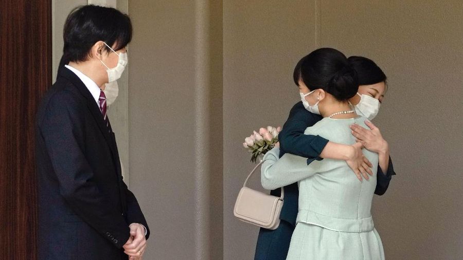 Japan's Princess Mako, right, hugs her sister Princess Kako, watched by her parents Crown Prince Akishino and Crown Princess Kiko, before leaving her home in Akasaka Estate in Tokyo Tuesday, Oct. 26, 2021. Mako and her commoner boyfriend Kei Komuro tied the knot Tuesday without wedding celebration in a marriage that has split the public opinion over her would-be mother-in-law’s financial controversy.  (Koki Sengoku/Kyodo News via AP)
