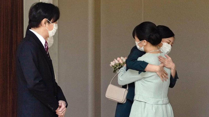 Japan's Princess Mako, right, hugs her sister Princess Kako, watched by her parents Crown Prince Akishino and Crown Princess Kiko, before leaving her home in Akasaka Estate in Tokyo Tuesday, Oct. 26, 2021. Mako and her commoner boyfriend Kei Komuro tied the knot Tuesday without wedding celebration in a marriage that has split the public opinion over her would-be mother-in-law’s financial controversy.  (Koki Sengoku/Kyodo News via AP)
