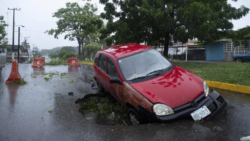 A car is stuck in a flooded street due to Hurricane Rick in Lazaro Cardenas, Mexico, Monday, Oct. 25, 2021. Hurricane Rick roared ashore along Mexico's southern Pacific coast early Monday with winds and heavy rain amid warnings of potential flash floods in the coastal mountains. (AP Photo/Armando Solis)