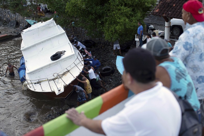 A car is stuck in a flooded street due to Hurricane Rick in Lazaro Cardenas, Mexico, Monday, Oct. 25, 2021. Hurricane Rick roared ashore along Mexico's southern Pacific coast early Monday with winds and heavy rain amid warnings of potential flash floods in the coastal mountains. (AP Photo/Armando Solis)