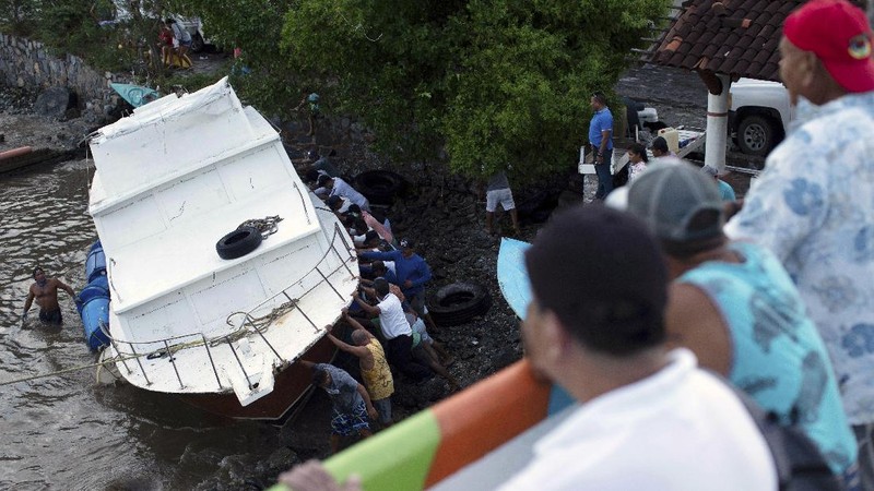 A car is stuck in a flooded street due to Hurricane Rick in Lazaro Cardenas, Mexico, Monday, Oct. 25, 2021. Hurricane Rick roared ashore along Mexico's southern Pacific coast early Monday with winds and heavy rain amid warnings of potential flash floods in the coastal mountains. (AP Photo/Armando Solis)